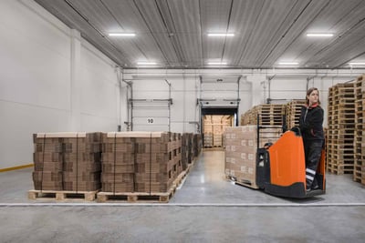 paletizado de mercacías en un almacén | Operaria manejando transpaleta eléctrica Levio serie S de Toyota